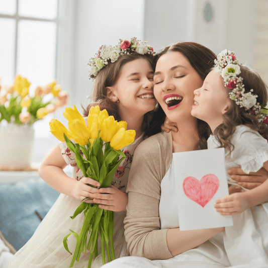 a picture of a mom with her two daughters hugging her