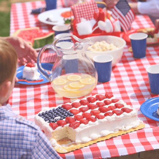 photo of a fourth of july party with a cake decorated like the a american flag