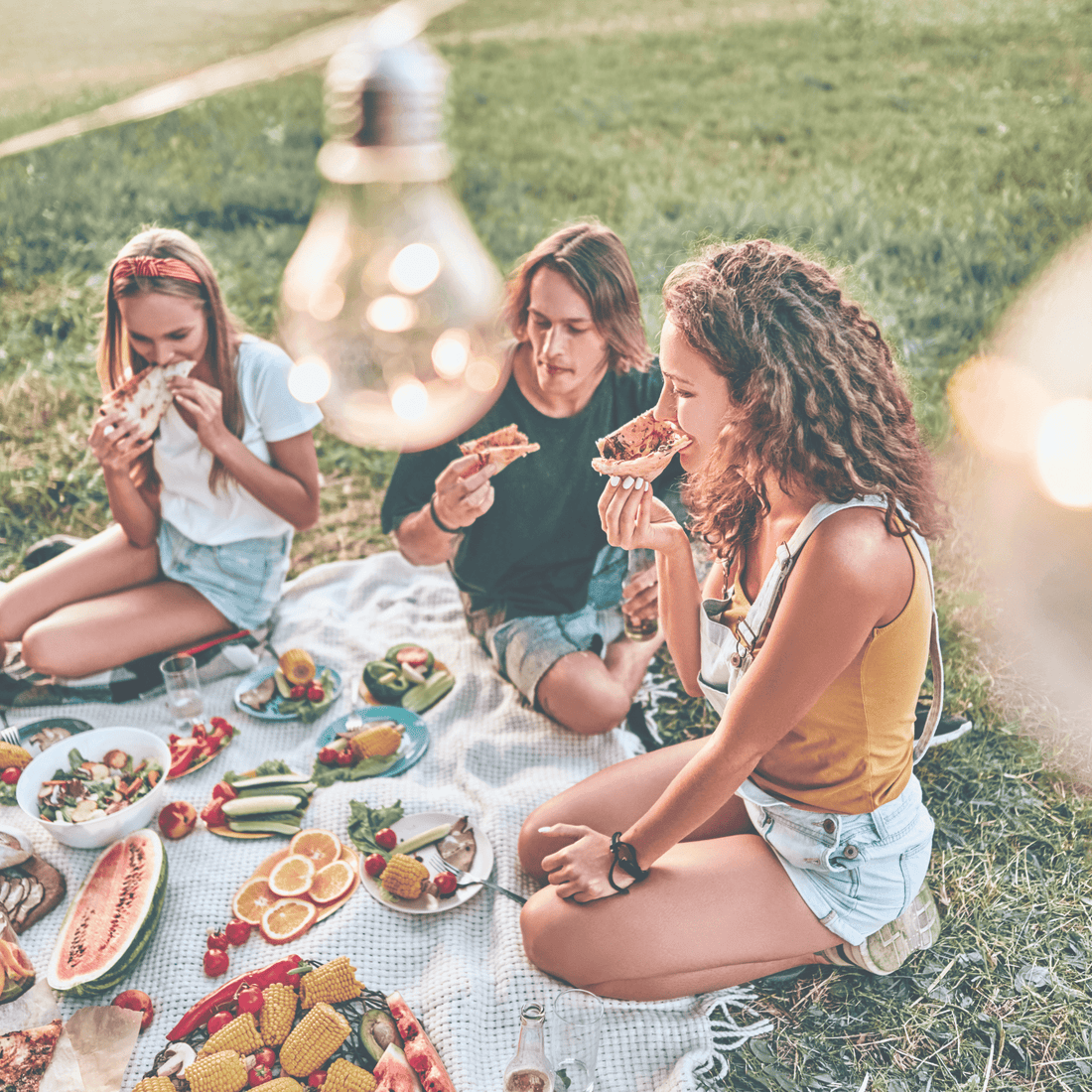 photo of 3 girls sitting and having a picnic